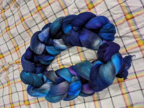a braid of fibre that's deep blues and purples, with occasional bits of grey and brighter blues and purples