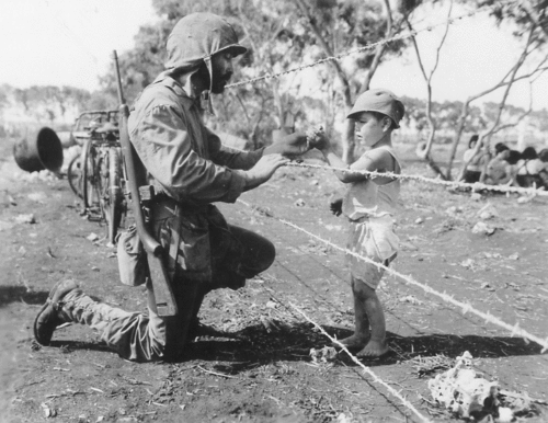 greatestgeneration:A US Marine gives food to a Japanese child in Saipan.