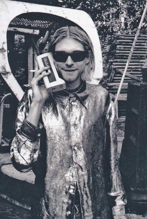 Kurt Cobain talking on an old school cell phone.