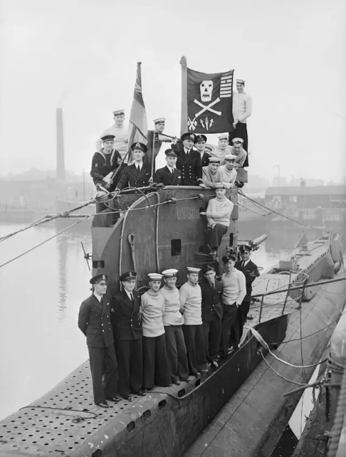 The Crew Of Royal Navy Submarine HMS Unison Display Their 'Jolly Roger' At Plymouth, Having Returned