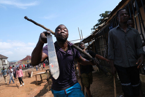 A man holds a panga blade as they chase a counter group during violent clashes, Abuja, on October 20