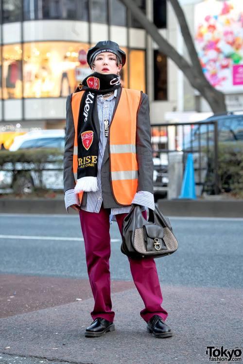 17-year-old Japanese student Lisa on the street in Harajuku wearing a vintage orange safety vest ove