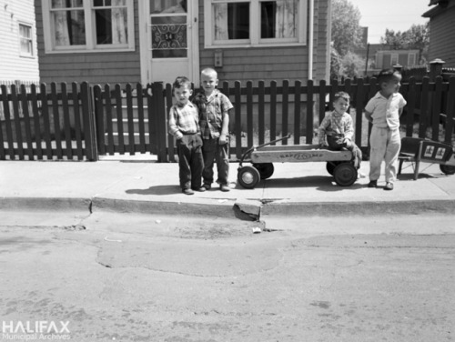 Four boys pose for the camera with their wagon and wheelbarrow. 54 Hennessey St., Halifax, Nova Scot