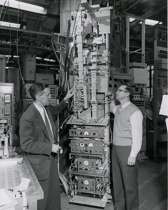 mudwerks:  Two men stand next to the apparatus of a television and telephone communications
