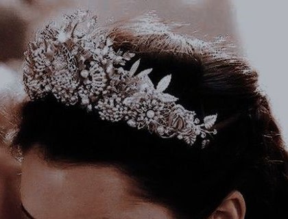 An image of a dark-haired woman wearing a silver tiara on their head