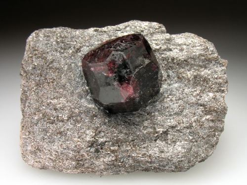 fuckyeahmineralogy:  Almandine, a type of garnet, in various stages of preparation.  Fully embedded in the matrix, as it would most commonly be found, and also jutting out of the matrix (I’m actually not sure if you find them like this, or if this