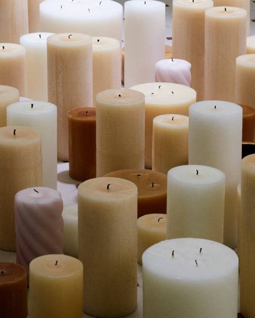 yuekinnie: [ID: a photo filled with many different sized and shaped neutral coloured candles. /end I