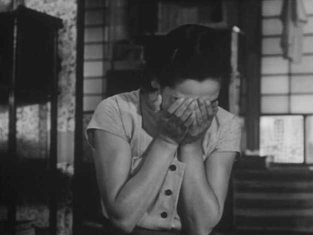 Black and white image of woman crying with her hands covering her face