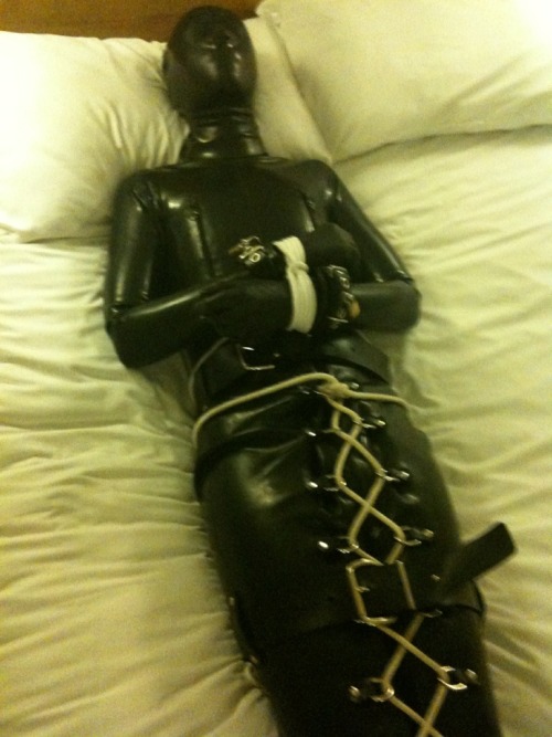 Full rubber, only nose holes. Ankles and knees bound with rope. Leg binder tightened and strapped up