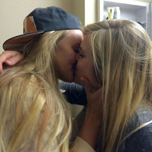 Two blonde girls making out with each other.