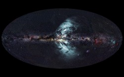 The image above shows the Milky Way in visible light, as we see it on a very dark night—stars, gas, and dust strewn across the sky. Superposed on that is the radio emission from those vast winds of material blasting outward (which is invisible to the