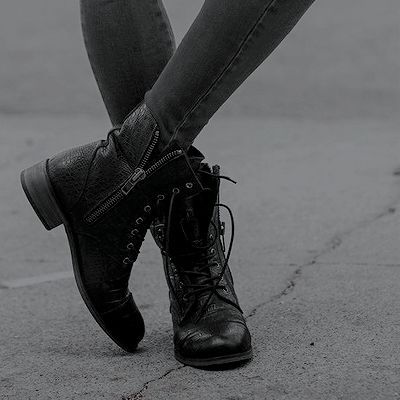An image of a person wearing grey leggings and black combat boots from the knee down