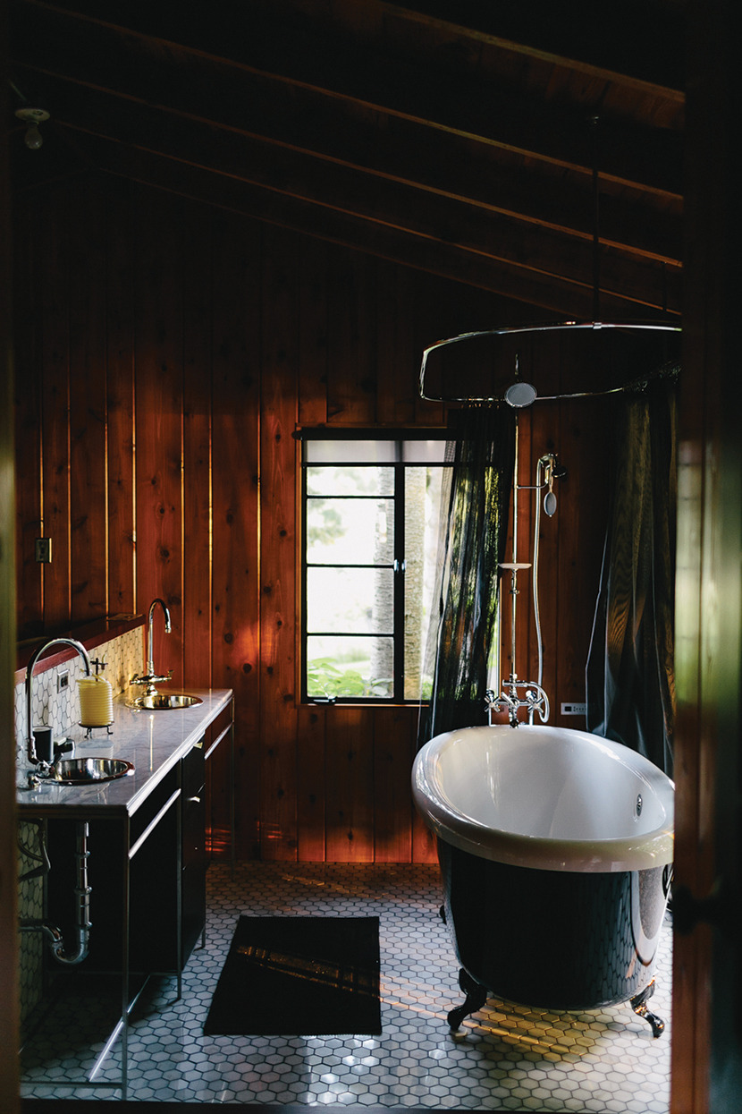 stylish-homes:  A claw foot tub stands in the center of a wood-enclosed bathroom.