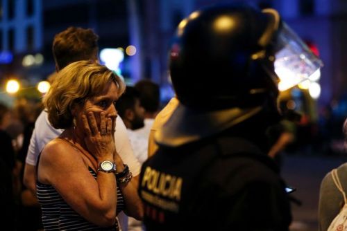  A woman gestures as she is escorted out by Spanish policemen outside a cordoned off area after a va