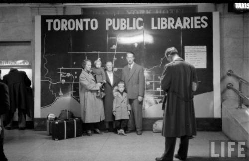Posing in front of a map of Toronto’s public libraries(Peter Stackpole. 1951)
