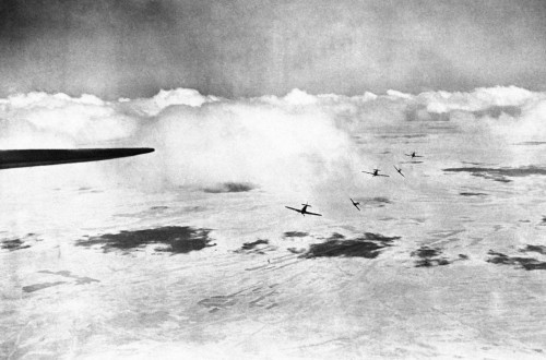 A patrol of British Hurricane fighter planes break formation toattack enemy aircraft, somewhere in t