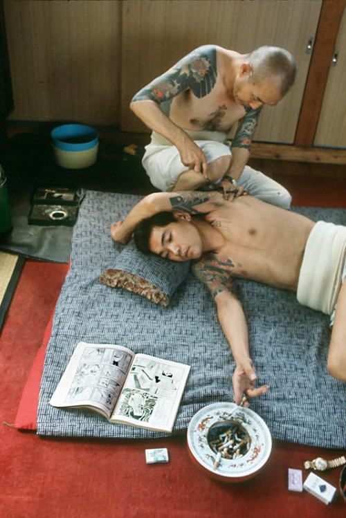 s-h-o-w-a:Man reading comics while being tattooed, Tokyo, Japan, 1970 by Martha Cooper