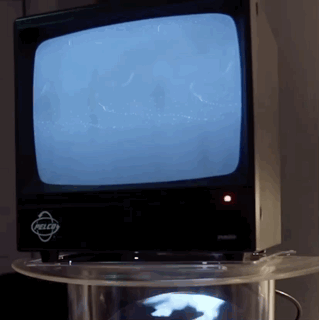 a gif of a white hologram of a rabbit entering a tv screen from below.