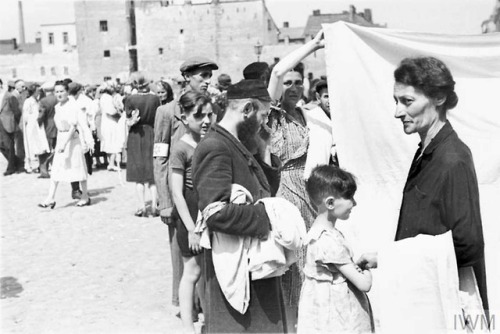 The Warsaw Ghetto (Poland, 1941):Shopping in a vegetable street market.Buying and selling bedsheets 