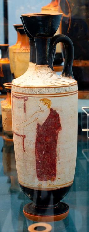 A draped youth is visiting a funerary stele. Attic white ground red figured lekythos. Attributed to 