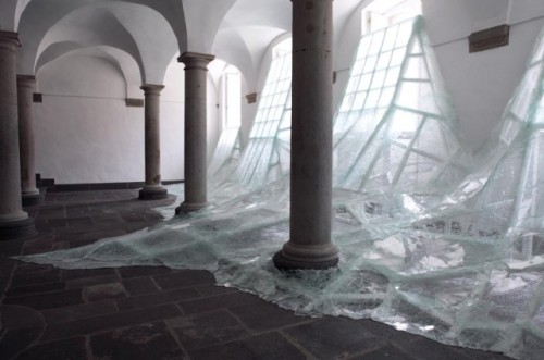 who-:Aerial is a new site-specific installation by Baptiste Debombourg at an old Benedictine monastery called Brauweiler Abbey near Cologne, Germany. Debombourg used numerous sheets of shattered laminate glass to mimic a frothy flood of water rushing