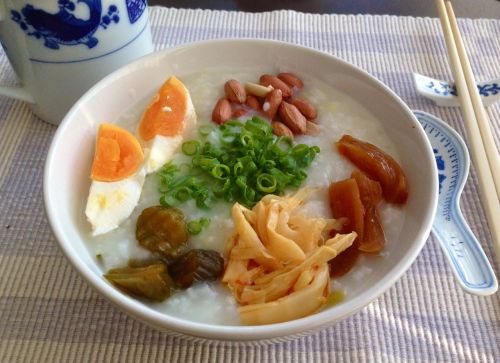 Simple Chinese breakfast: rice porridge with peanuts, scallions, pickled radish, pickled bamboo shoo