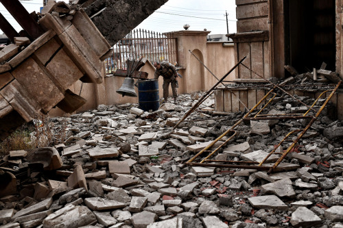 A member of the Nineveh Plain Protection Units rings the bell of a destroyed church in Bakhdida, on 