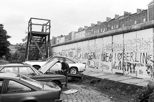 The Berlin Wall on Bernauer Strasse 1986. This guy appears to be running a car repair business right