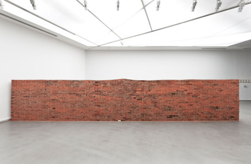 thedesigndome:  A Single Book Can Alter The Strongest Of Foundations Installation artist Jorge Mendez Blake creates a powerful brick sculpture titled “The Castle”. The intimidating wall, formidable and erect, loses its symmetry and forms a rift at