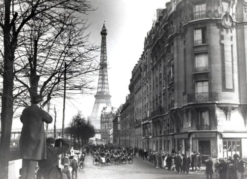 In this picture from January 1920, a triporteurs race is shown passing under a backdrop of the Eiffe
