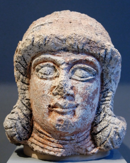 Ancient Mesopotamian painted terracotta sculpture, representing a woman with braided hair.  Artist u