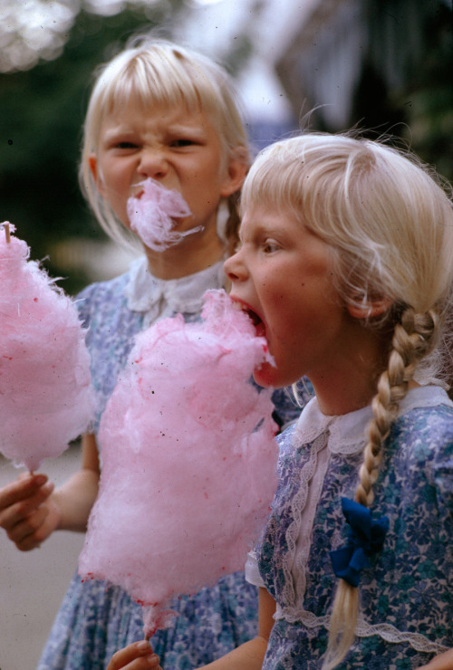 Girls eat large swirls of cotton candy in Copenhagen, Denmark, January 1963.Photograph by Gilbert M.