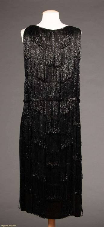 the1920sinpictures: 1928 c. Evening dress of jet bugle beads in long, tiered bands. The center front