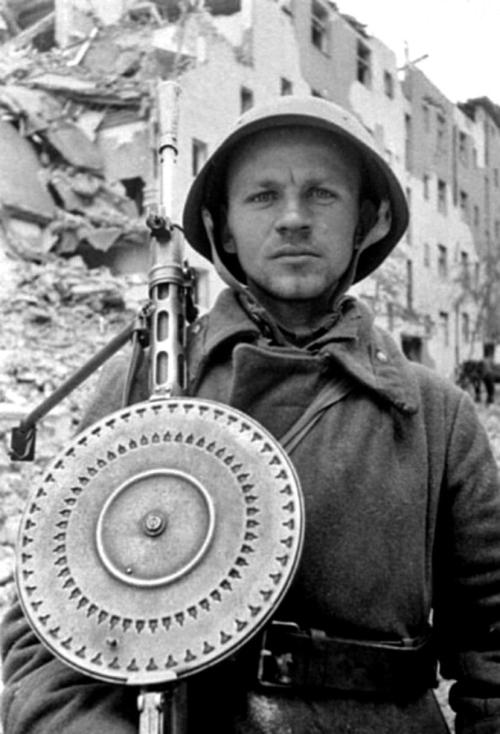 historicaltimes:A portrait of a Soviet soldier carrying his Degtyaryov DP-28 light machine gun durin