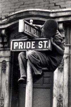 yet-another-universe:  Pride Street  W. Eugene Smith   “Pittsburgh (Boy Hanging on Colwell &amp; Pride St. Sign) 1955-56” 