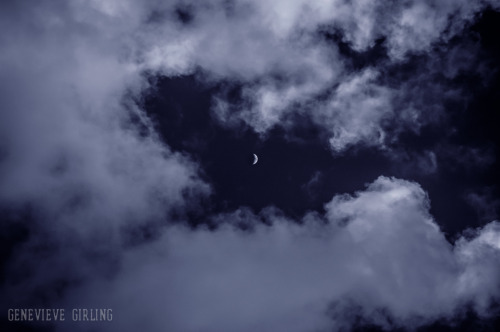 Waxing crescent moon in the clouds.Taken with an infra-red lens which gives the sky its dark colour 