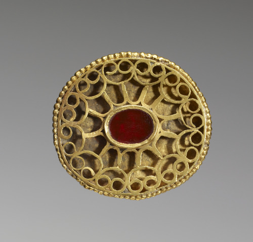 artofthedarkages: A disc fibula with openwork decoration. Crafted out of gold, with a carnelian gem 