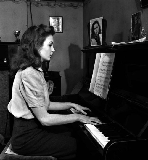 musicbabes:  Jean Simmons reading sheet music as she plays her piano at home, 28th February, 1946. 
