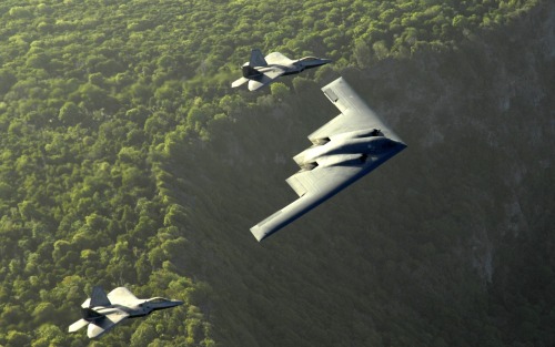 A B-2 Spirit bomber with two F-22 Raptors for escort.