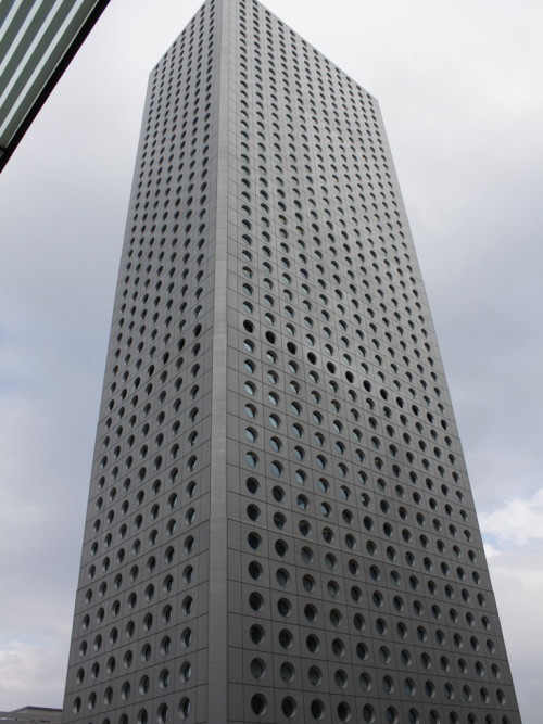 architectureland:  Jardine House  - Palmer & Turner The building is constructed with a metal frame, and a curtain wall with round windows. The thickness of the structural frame is reduced because of the shape of the windows. Unusually for a Jardine