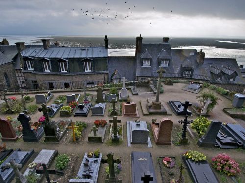 A graveyard at the Abbaye de Mont St.-Michel in Normandy offers a sweeping view of the Bay of Mont S