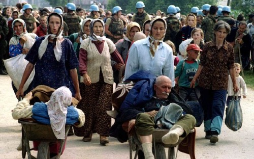 July 1995: A group of Bosnian Muslims, refugees from Srebrenica, walk to be transported from the eas