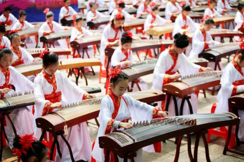  Teenagers dressed up in traditional costumes play the Chinese instrument Zheng in the Gulongzhong s