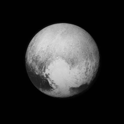 At long last, and for the first time, the surface of Pluto. And the first high-resolution photograph