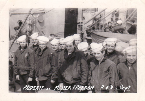 On this vintage photo from our archives, US Navy sailors are standing on deck wearing a mix of 1st T