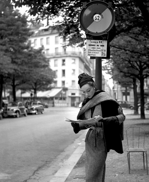 Sophie Litvak reading at bus stop in Paris wearing a Lanvin Castillo creation. Elle, September 1952.