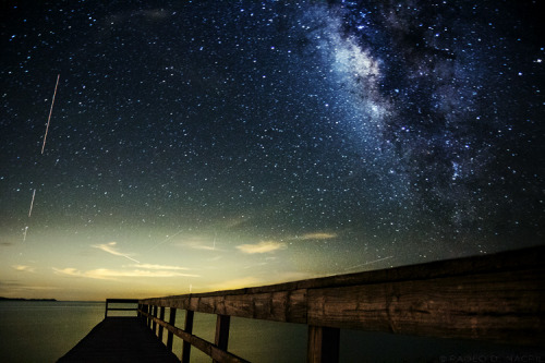 capturedphotos:  Ground Control to Major Tom Image taken in Cedar Key, Florida. I’m not exactly sure what the almost vertical light streak is on the left side of the image - satellite or airplane or rocket? This is a single 60 second exposure at ISO