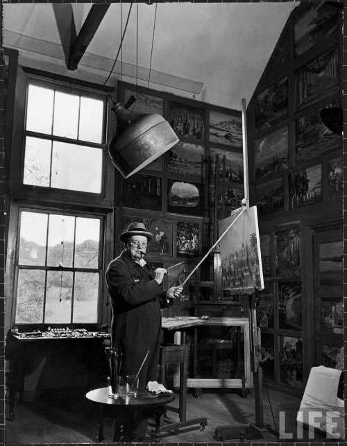 Former PM Winston Churchill smoking a cigar as he stands in his studio dressed in his blue RAF siren