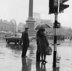 undr:  Moore/Stringer Pedestrians wait to cross the street on a rainy day in Trafalgar Square, London.  1962 