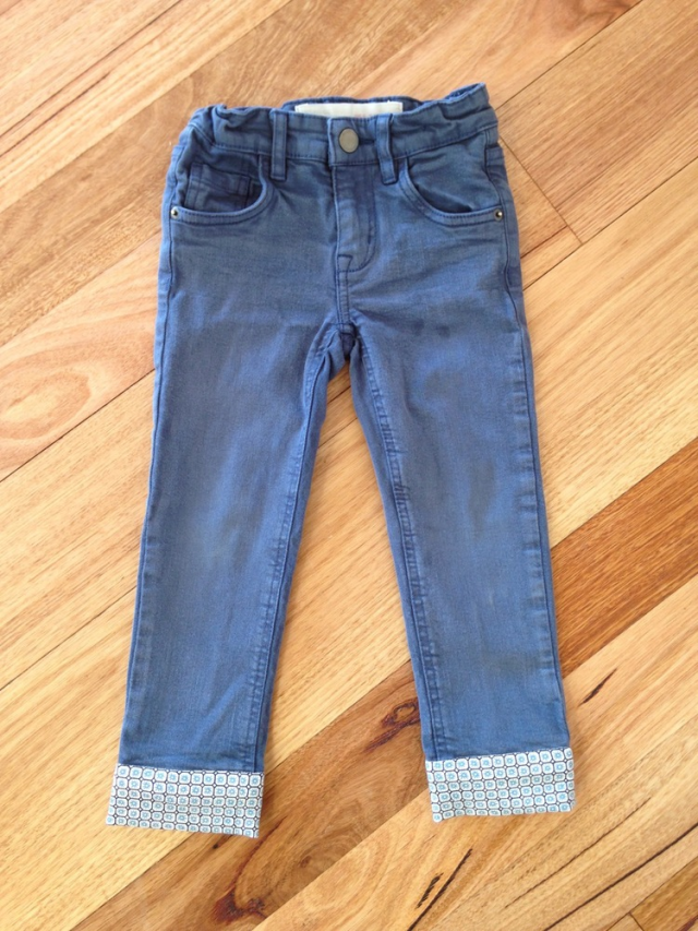A pair of blue pants with blue and brown cuffs down onto the bottom of the legs.